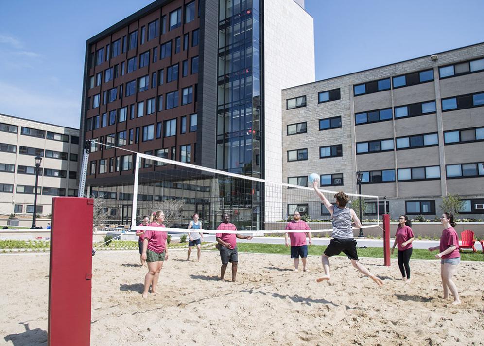 Students play volleyball outside The Tower.